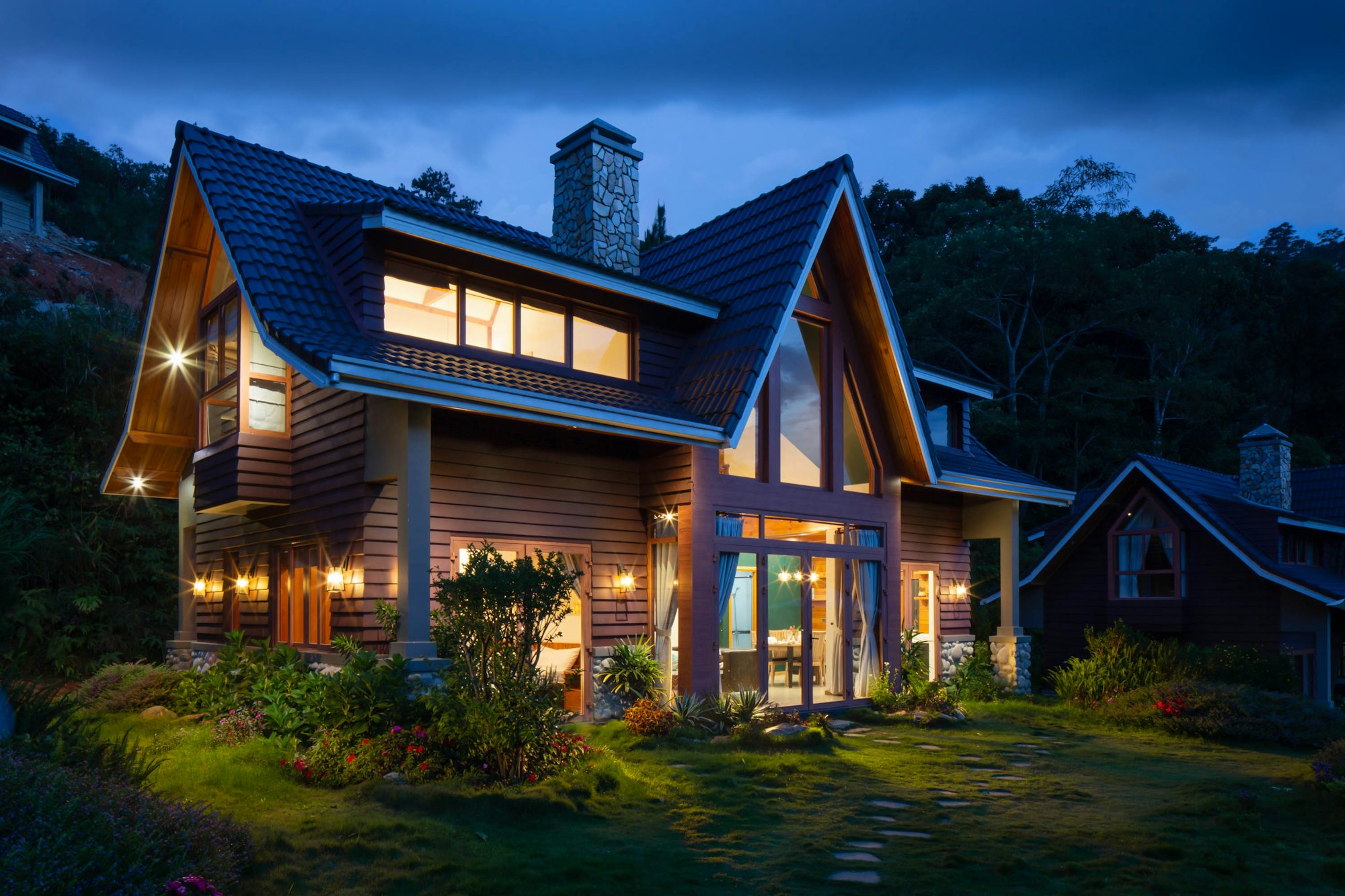 Gabled home with warm lights against an evening sky